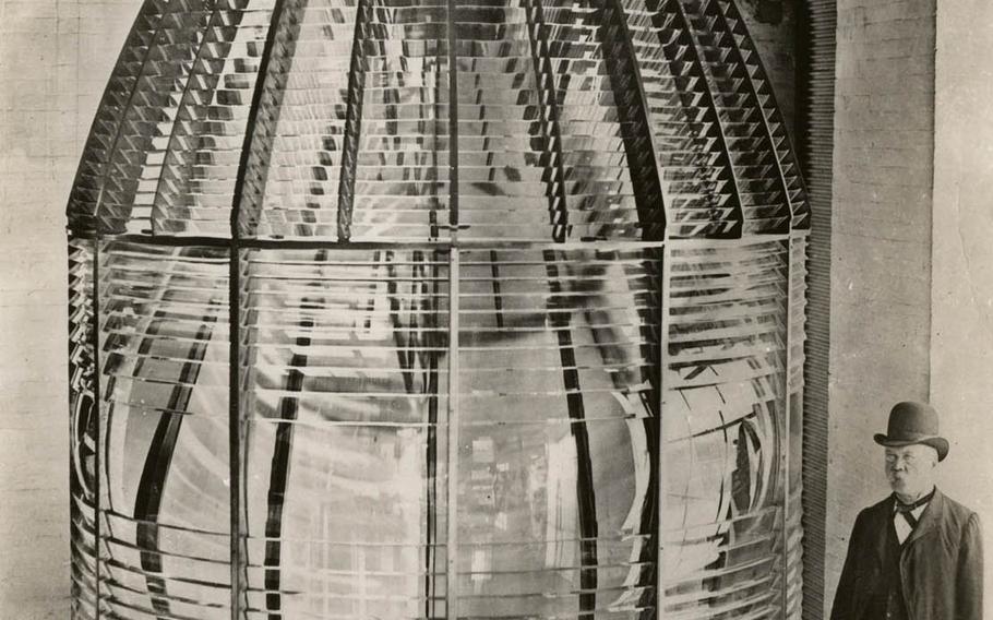 A man stands next to the world's largest lighthouse lens, used at Makapu'u Point Lighthouse, in this undated photograph.