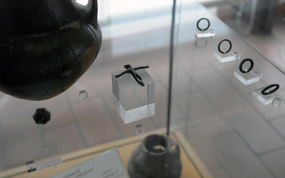 A bronze pendant in the shape of a human figure is one of the items taken from an eighth century B.C. tomb excavated on the site of the U.S. Navy base in Gricignano, Italy. The pendant is part of the permanent exhibit at the Archeological Museum of Agro Atellano.