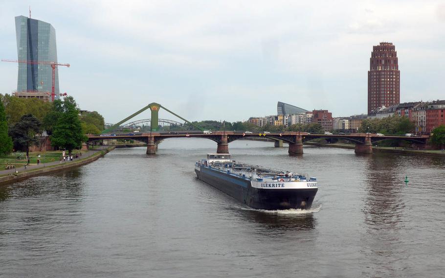 A freighter plies the Main River with two of Frankfurt's distinctive high-rises on each bankof the river. At left is the new European Central Bank Headquarters that opened last year, and at right the Main Plaza, built in the architectural style of early 20th-century New York high-rise buildings.