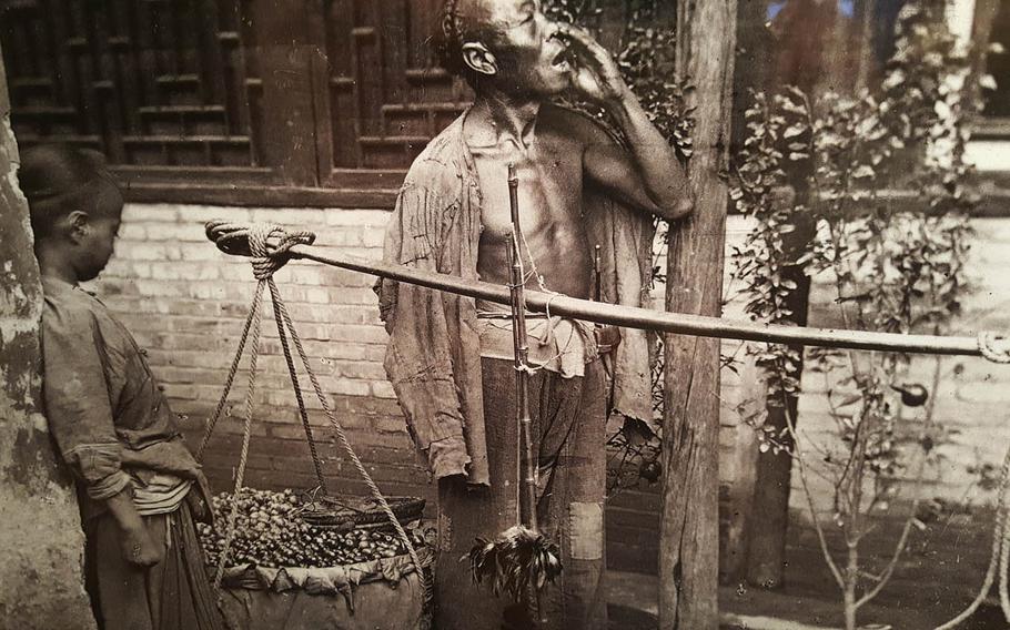 A fruit-seller beckons customers in Beijing in this photo taken by John Thomson during his 1871-72 trip to China. The photo is now on display at the East-West Center Gallery in Honolulu.