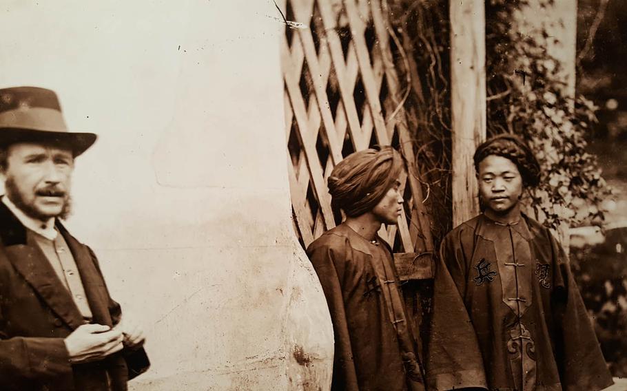 John Thomson stands beside two Manchu soldiers in Xiamen, Fujian Province, China, in 1871, in this photo on display at an exhibit of the Scottish photographer's work at the East-West Center Gallery in Honolulu. Thomson rarely appeared in the photos he shot.