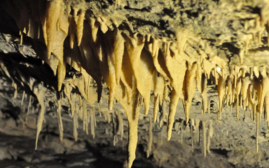 Much of the interior of Grotta Nuova di Villanova appears to be shades of white or gray, but there are some yellow patches created by a different set of minerals.