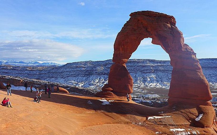Winter tourists photograph Delicate Arch, an iconic rock structure at Arches National Park, in eastern Utah. Photo by Elizabeth Zach for The Washington Post