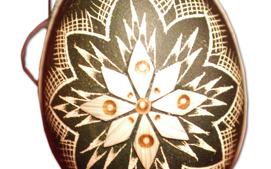 This egg has been dyed, then the designs were carved in it, and finally the straw star was applied. The technique comes from Hungary.