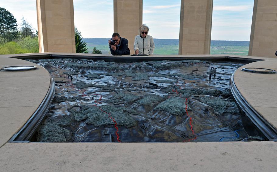 Visitors to the Montsec American Monument look at the bronze map of the St. Mihiel Salient battlefield that is the centerpiece of the monument. The red lines mark the different positions of the front line during the battle in August and September 1918.