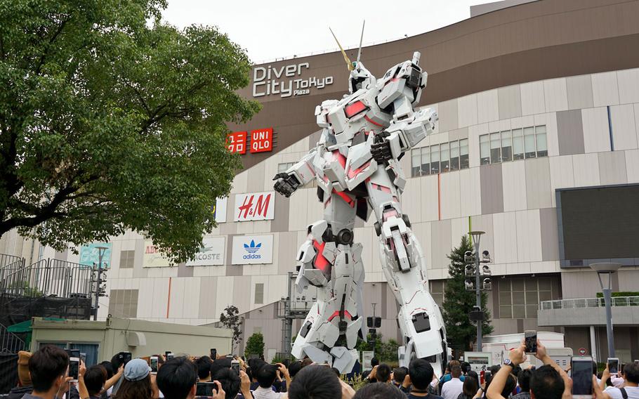 The Unicorn Gundam statue in Odaiba, Tokyo, is pictured halfway through its transformation into battle-ready destroy mode, Thursday, Sept. 28, 2017. The process takes about 10 seconds and occurs several times daily.