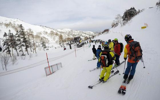 Skiers and snowboarders wait for a lift at Kagura ski resort in Niigata Prefecture, Japan. 