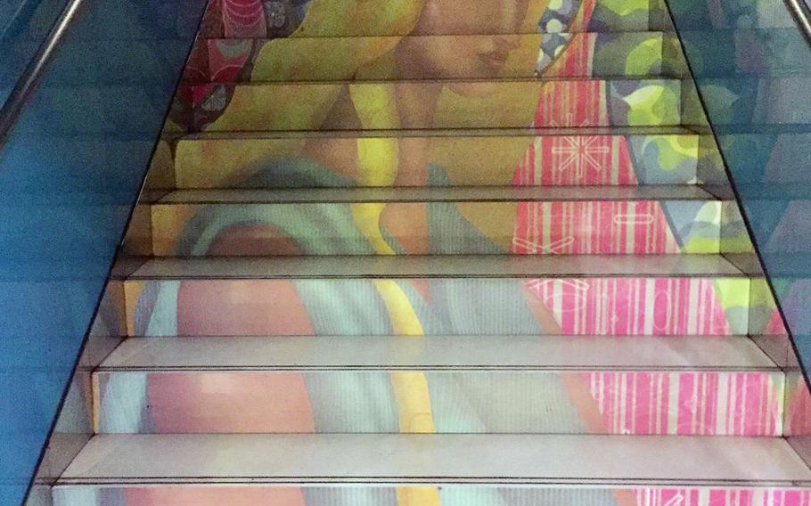 A mural of a woman on the stairs of the University Metro Station in Naples, Italy. Colorful, eye-catching art can be seen throughout the city's subway system, especially at the Toledo, University and Montecalvo stations.