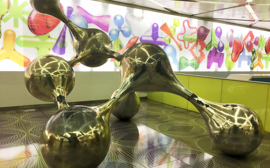 A metallic sculpture represents the intertwining shapes in the abstract mural at the University Metro Station in Naples, Italy. About 100 artists produced works seen at various subway stations in the city.