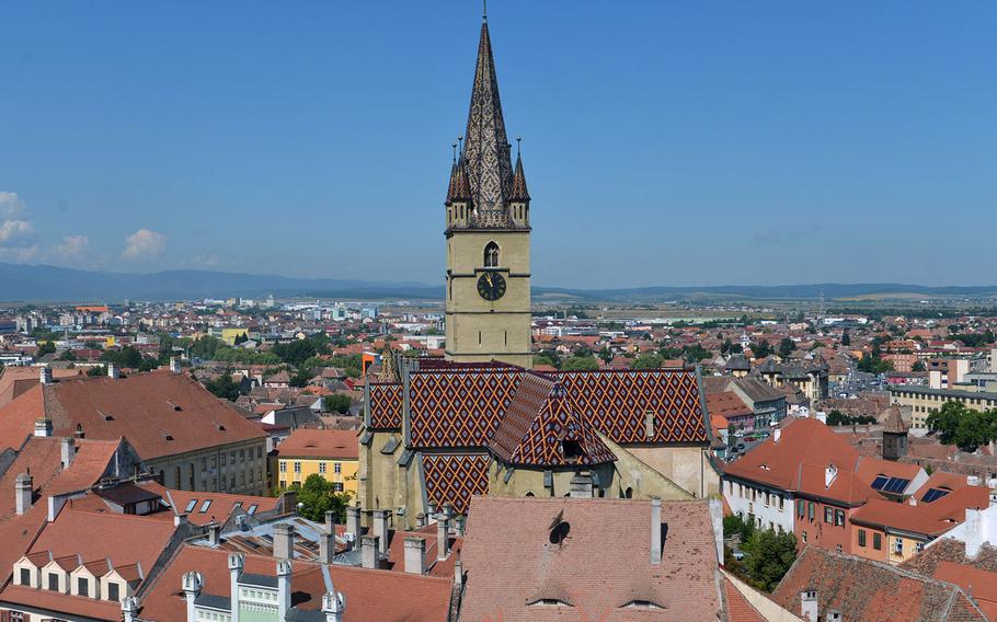 The beautiful tile roof and steeple of Sibiu, Romania's Evangelical l Cathedral as seen from the 13th-century Turnul Sfatului, or Council Tower.