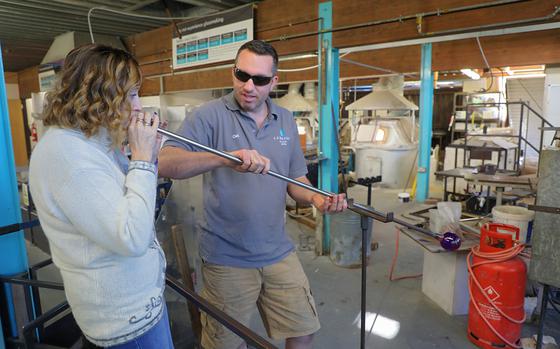 Linda Grange, left, blows down a blowtube while Carl Fait, right, spins the glass tree ornament she's making to help it keep its round shape, at Langham Glass in Fakenham, England, on Nov. 19, 2019. 

