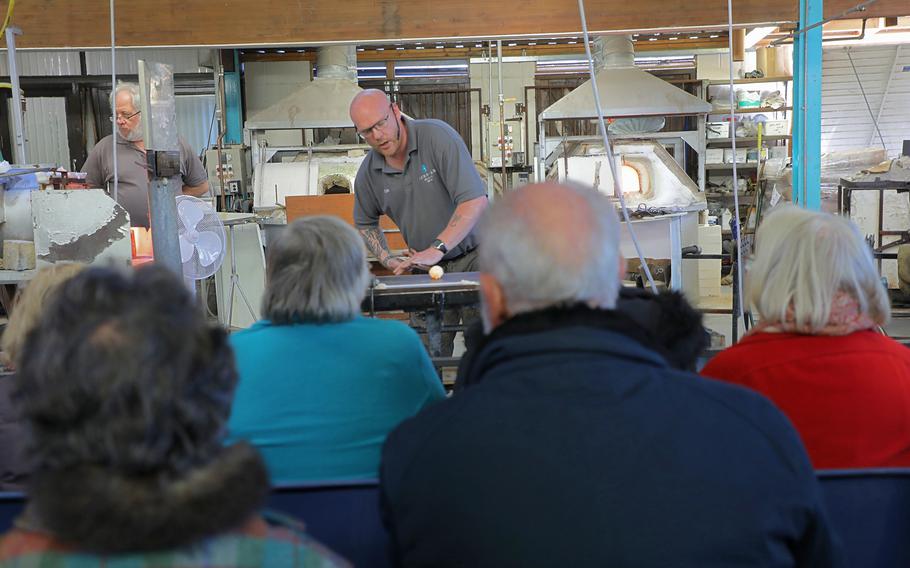 Christopher Stone molds a glass object as he demonstrates to a tour group how to shape glass at Langham Glass in Fakenham, England on Nov. 19, 2019.