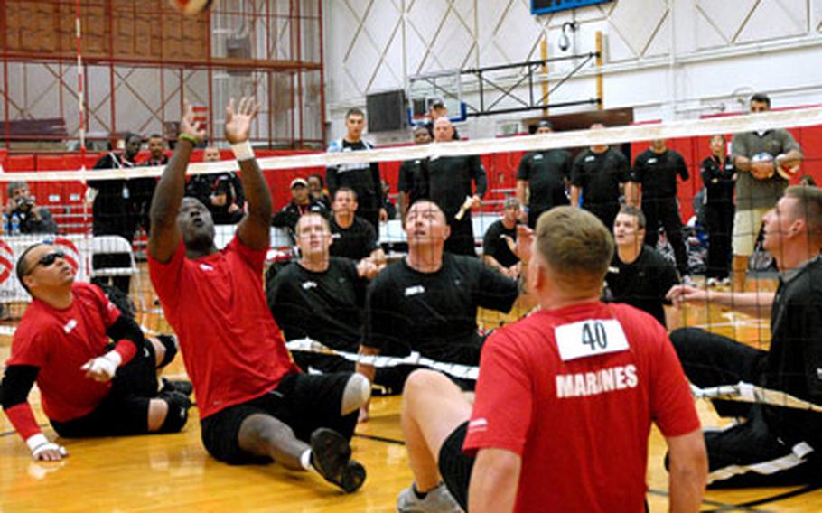 Gunnery Sgt. Marcus Wilson sets the ball to a teammate during a sitting volleyball game last week at the Warrior Games in Colorado Springs, Colo. He wears a rubber bracelet that says "courage," and over the last two and half years has become a touchstone for him.