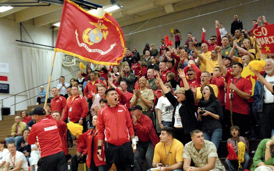 To pump up the Marines during the sitting volleyball gold medal game against Army, a Marine runs the service's flag past the crowd last week at the Warrior Games in Colorado Springs, Colo.