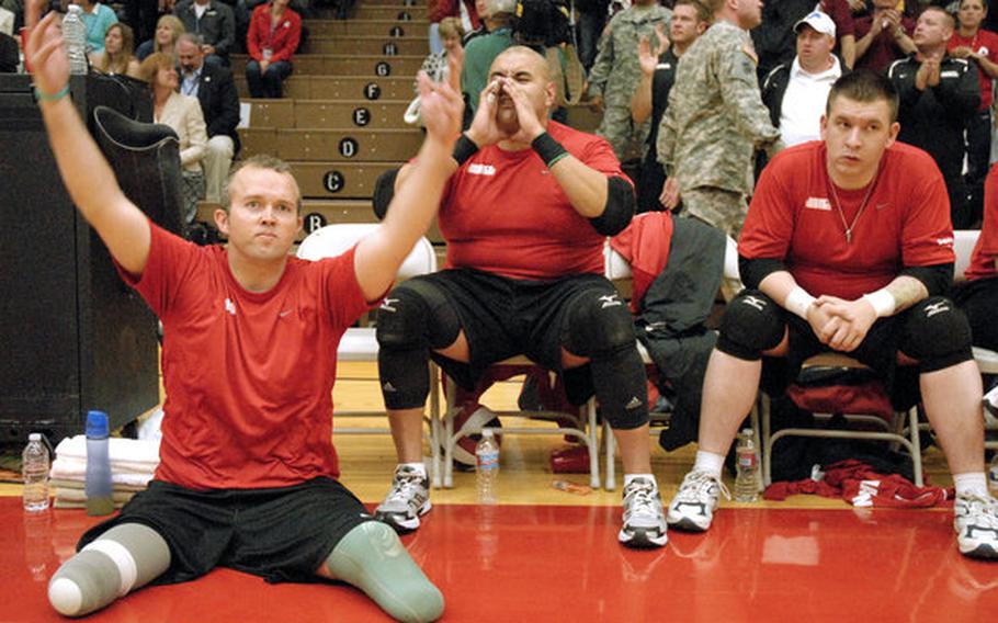 Former Sgt. Bradley Walker, left, a member of the Marine sitting volleyball team, motions to the crowd to get excited as the Marines worked to win gold against Army last week at the Warrior Games in Colorado Springs, Colo. Walker, a combat engineer, was attached to Wilson's unit in Haditha, Iraq, and was hit by an IED two weeks after Wilson was.
