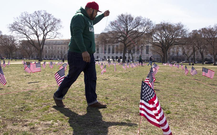 A member of Iraq and Afghanistan Veterans of America (IAVA) helps plant flags on the National Mall in Washington, D.C., on March. 27, 2014. A total of 1,892 flags were planted, each representing the number of veterans and servicemembers estimated to have committed suicide so far in 2014.
