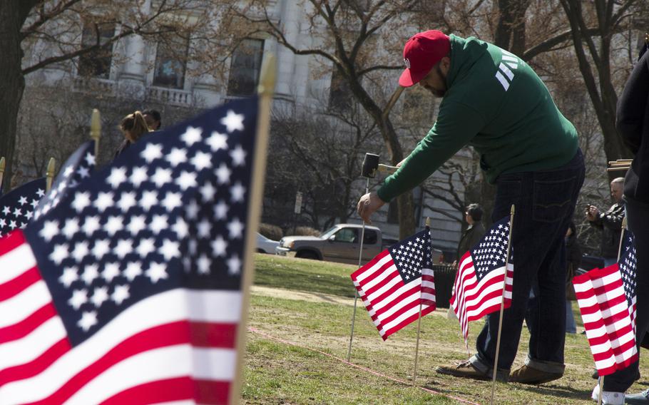 A member of Iraq and Afghanistan Veterans of America (IAVA) helps plant flags on the National Mall in Washington, D.C., on March. 27, 2014. A total of 1,892 flags were planted, each representing the number of veterans and servicemembers estimated to have committed suicide so far in 2014.