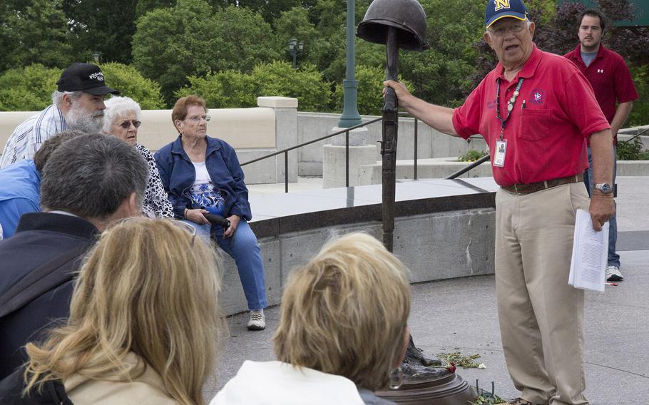 Guide Walter Johnson, a 23-year Navy veteran, explains the sculpture "Final Tribute," representing a battlefield grave, at the National D-Day Memorial in Bedford, Va.