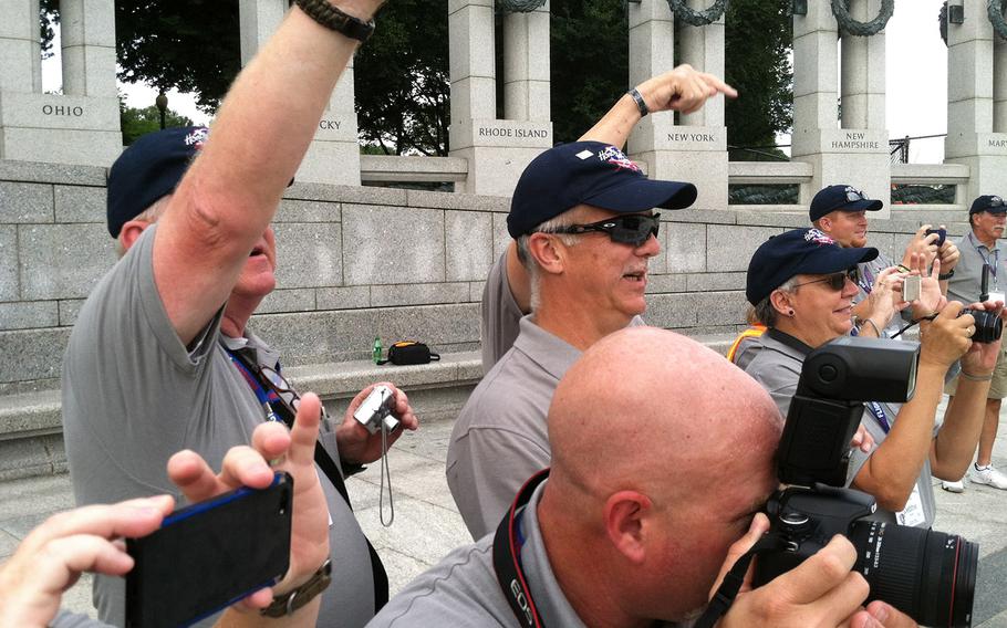 Guardians accompanying veterans on the Honor Flight of Idaho take photos of the group at the National World War II Memorial in Washington, D.C., September 3, 2014.