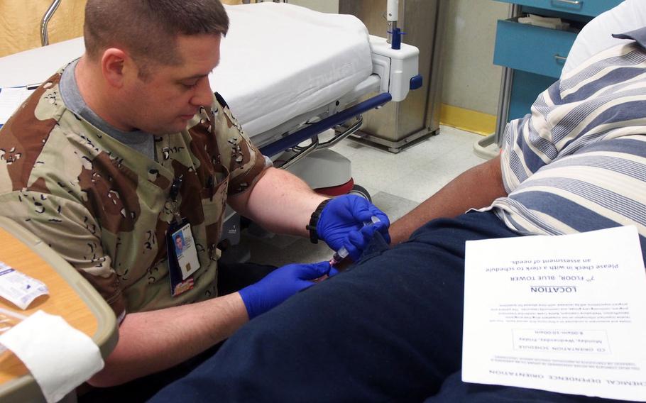 Former Army medic Scott Garbin takes blood from a patient at the John Dingell VA Medical Center in Detroit. Garbin is part of a group of former medics and Navy corpsmen participating in a Department of Veterans Affairs program to place them in healthcare jobs at VA hospitals.
