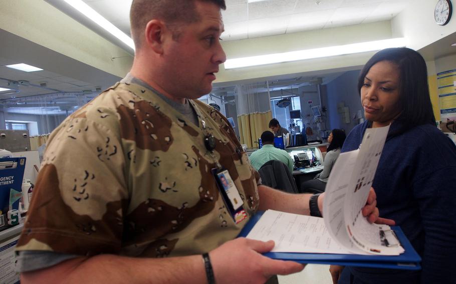 Former Army medic Scott Garbin wears camouflage scrubs on the job, in part to better connect with the fellow veterans he treats at the John Dingell VA Medical Center in Detroit. Garbin is part of a VA program that gives former military health care professionals VA job and helps the department fill a critical shortage.
