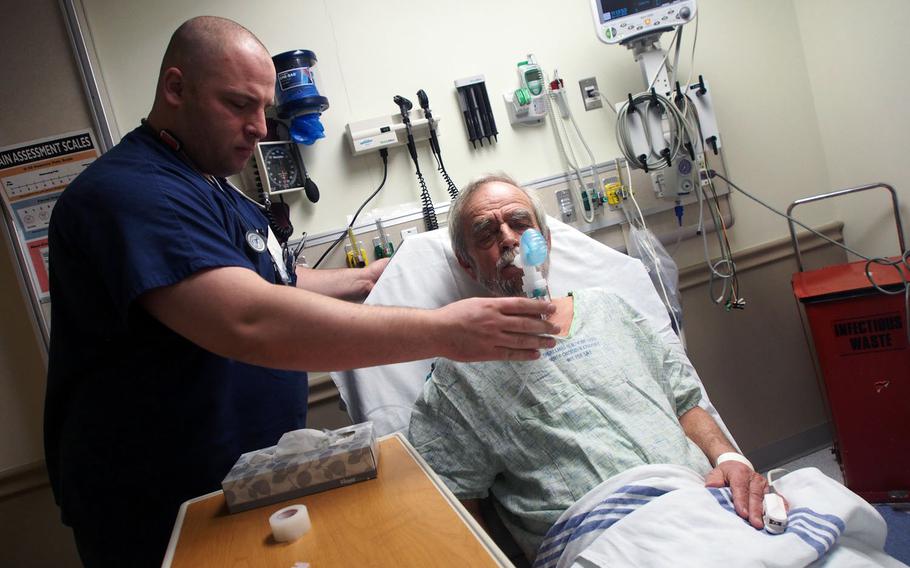 Former Army combat medic Joe Carney attends to a patient at James Lovell Federal Health Care Center in North Chicago, Ill. Like many former medics, Carney struggled to find work after leaving the military, but is now part of a VA program that places such veterans in healthcare jobs.


