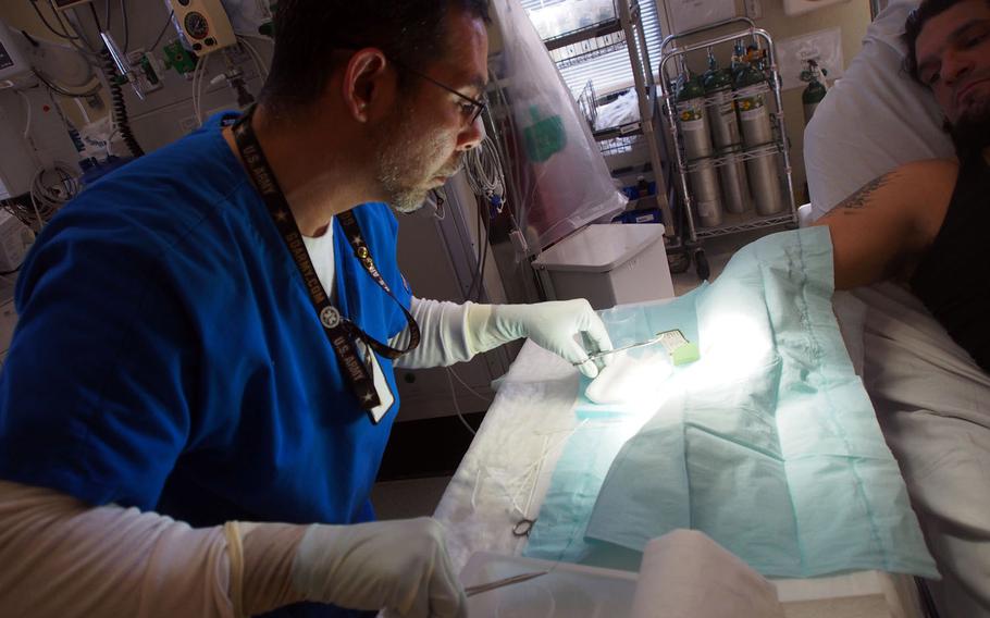 Conrad Siat sutures a wound at the John Dingell VA Medical Center in Detroit. Siat is part of the Intermediate Care Technician program, which gives former Army medics and Navy corpsmen, who often struggle to find similar work in teh civilian world, medical employment at VA hospitals.