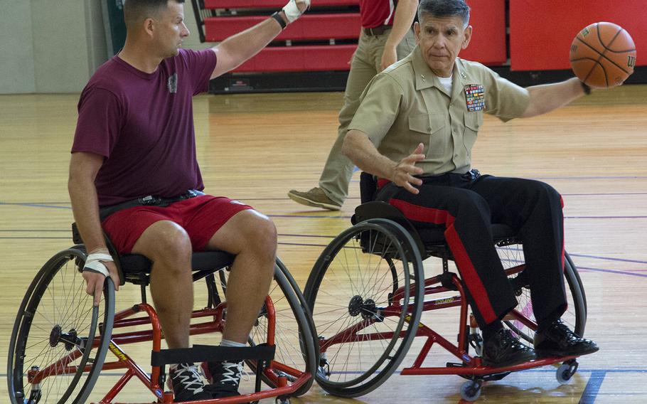 Maj. Gen. Juan Ayala, commanding general of the Marine Corps National Capital Region, prepares to pass the ball as he works out with wheelchair basketball players in advance of the 2015 Warrior Games at Marine Corps Base Quantico, June 18, 2015.