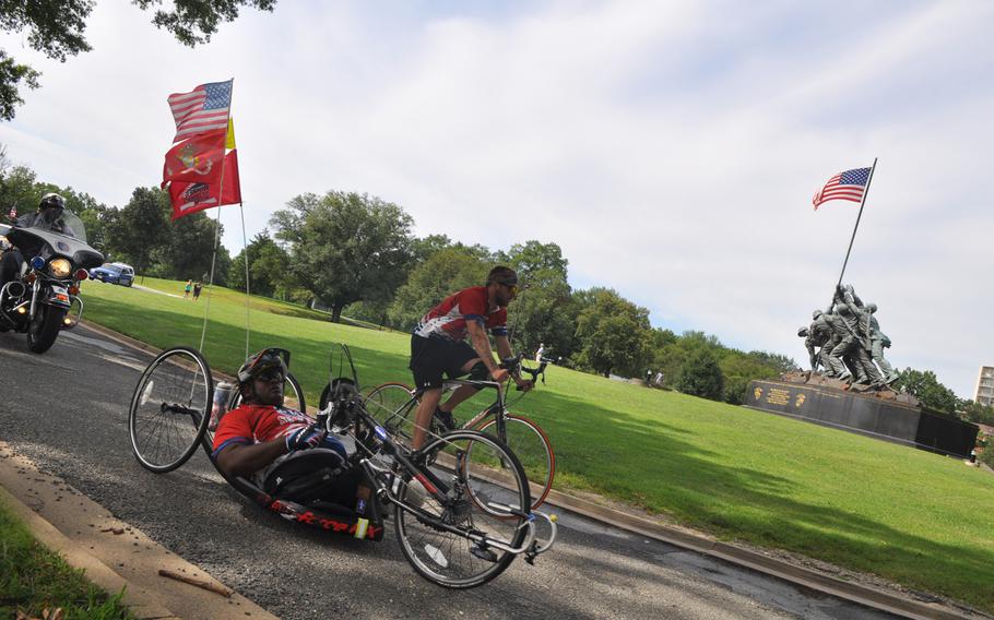 Former Marine Toran Gaal (sit-down bicycle) cycles past the Marine Corps War Memorial in Arlington, Virginia Sunday at the end of a more than 4,000 mile journey across the country. Gaal, who lost both legs and suffered a severe brain injury in Afghanistan was riding to raise money for the Semper Fi Fund and to inspire other wounded veterans. 