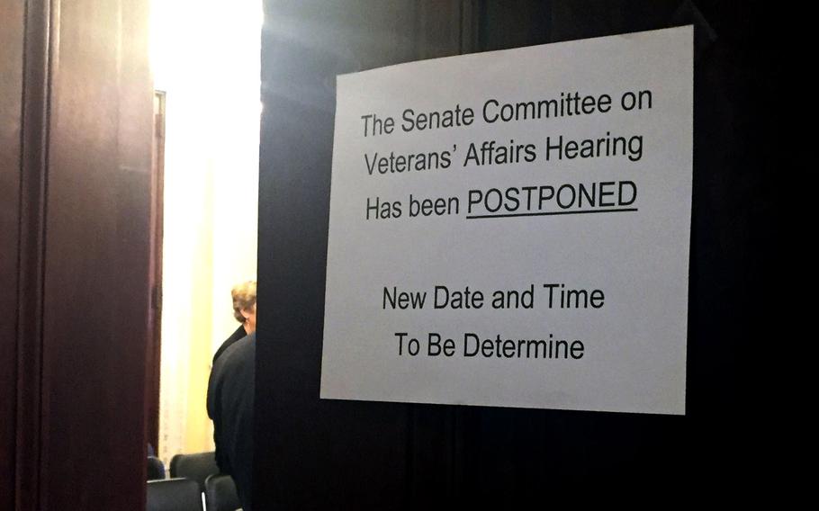 A sign on the hearing room door tells of the postponement of a hearing on May 10, 2017.