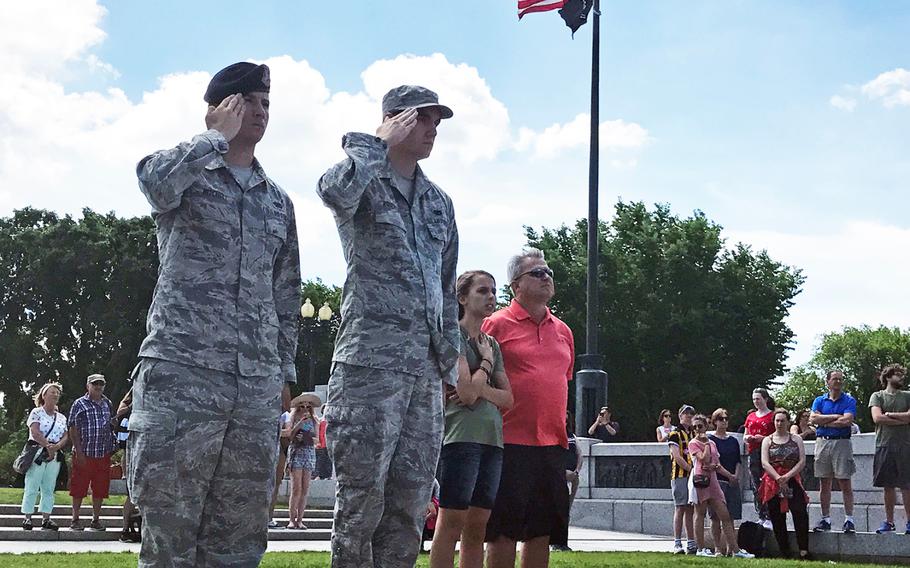 Two servicemembers salute during the 73rd commemoration of D-Day at the World War II Memorial in Washington, D.C., on June 6, 2017,