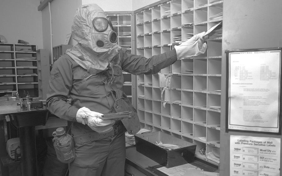 Airman 1st Class Harry Leonard, postal clerk, sorts mail while wearing nuclear-biological-chemical gear during a test to evaluate his unit's ability to perform under fallout conditions in October, 1978. 