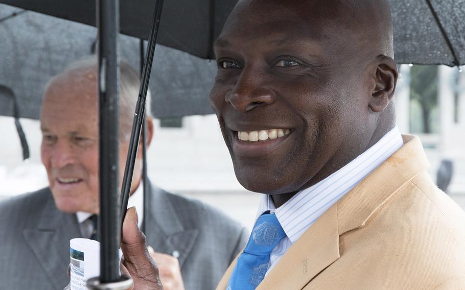 Josiah Bunting III, chairman of the Friends of the National World War II Memorial, and pro football Hall of Famer Bruce Smith try to stay dry before a ceremony marking the 72nd anniversary of V-J Day, September 2, 2017,l in Washington, D.C.
