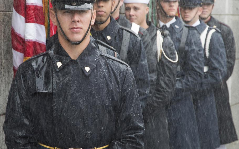 Members of the U.S. Armed Forces Color Guard stand in a downpour before a ceremony marking the 72nd anniversary of V-J Day, September 2, 2017 at the National World War II Memorial in Washington, D.C.