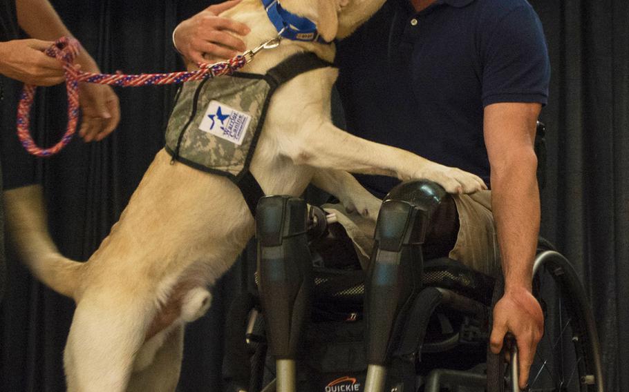 Capt. Dan Berschinski receives a kiss from his service dog Bunce during the Warrior Canine Connection's graduation ceremony on Oct. 7, 2017.