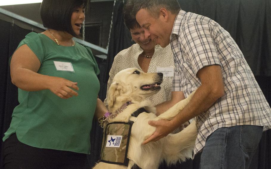 Service dog Katie jumps on her owner Randy Nieves during the Warrior Canine Connection's graduation ceremony on Oct. 7, 2017. To the left were Katie's puppy parents Karen Chiu and Stephanie O'Brien.
