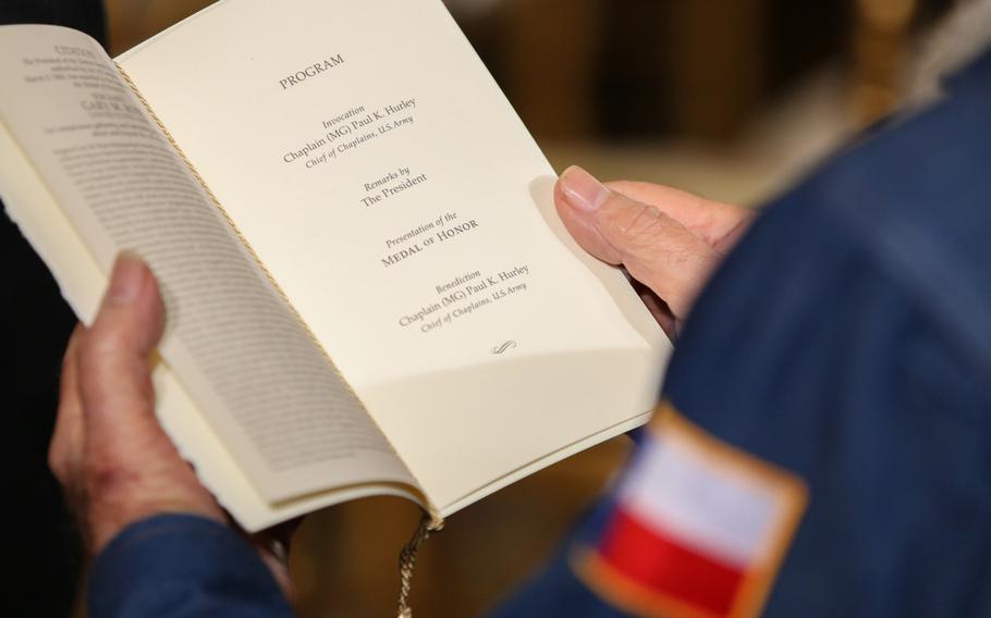 An attendee reads the program for the presentation of retired Army Capt. Gary M. Rose's Medal of Honor at the White House on Oct. 23, 2017.