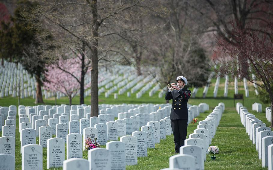 A bugler from The U.S. Navy Band plays Taps during in the full honors funeral of U.S. Navy Capt. Thomas J. Hudner in Section 54 of Arlington National Cemetery, Virginia on Apr. 4, 2018.  