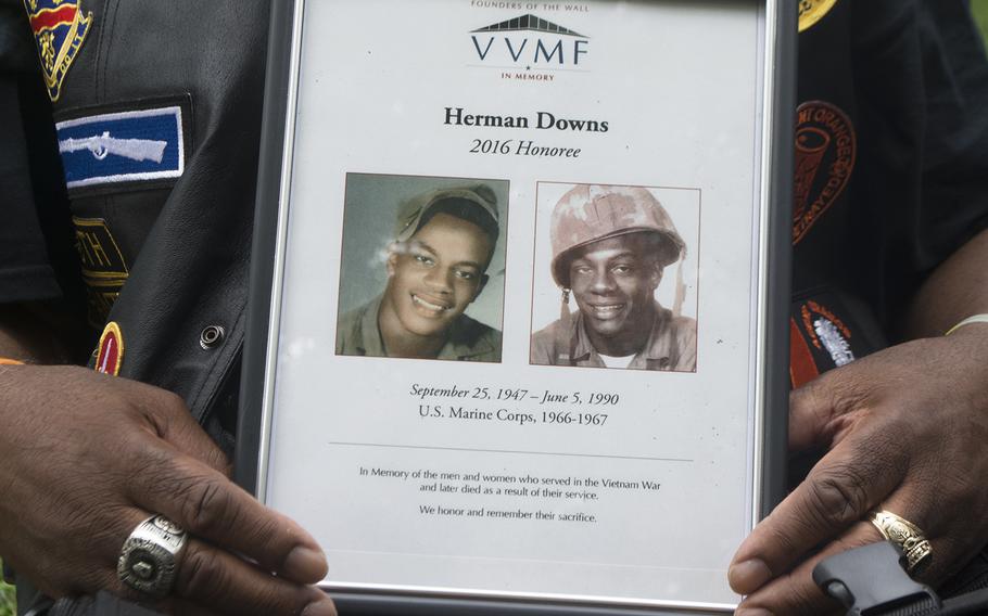 Johnnie Downs holds up a photo of his brother Herman after walking through the Vietnam Memorial Wall. Herman died as a result of exposure from Agent Orange in 1990. Johnnie thought of him as he placed a few roses along the wall as part of annual Father's Day Rose Remembrance. 