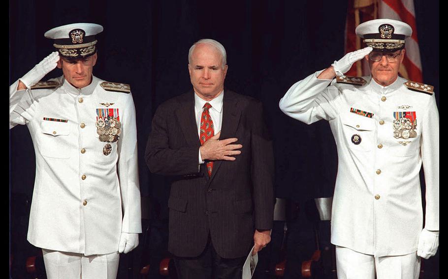 From left, Adm. Jay L. Johnson, Chief of Naval Operations, Sen. John McCain III, R-AZ, and outgoing superintendent of the United States Naval Academy Adm. Charles R. Larson stand at attention during the playing of the National Anthem during change of command ceremonies in Annapolis, Maryland on June 4, 1998.