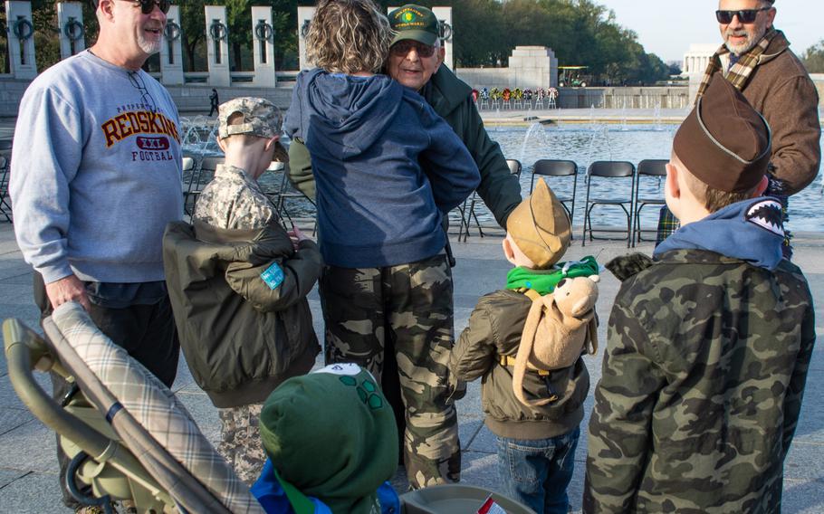 The Witherington family visited the World War II Memorial on Veterans Day to watch their friend, Bob Swain, be honored during the Parade of Heroes. From left to right: dad George Witherington, son Ryder, wife Karen hugging WWII veteran Bob Swain, Ryver Witherington and brother Rydge Witherington. In the stroller is their littlest brother, Ranger. Ryver and Rydge were both wearing Swain's WWII hats.