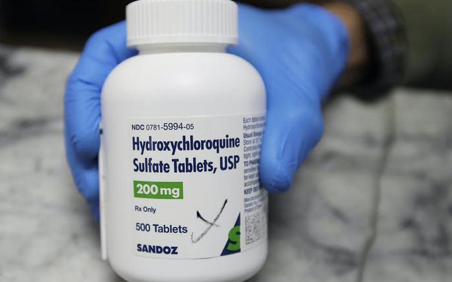 A pharmacist shows a bottle of the drug hydroxychloroquine.