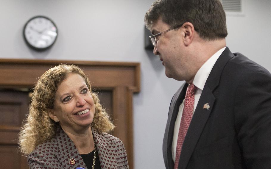 Rep. Debbie Wasserman Schultz, D-Fla., talks with VA Secretary Robert Wilkie before a Capitol Hill hearing in 2019. At a hearing this week, Wasserman Schultz called the VA's dedcision to keep maintaining tombstones adorned with swastikas "deeply troubling."