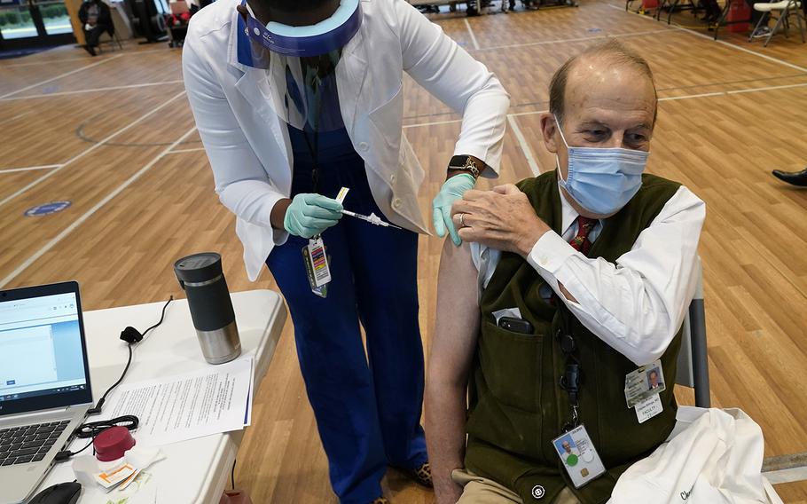 Dr. Charles Billings, a staff orthopedic surgeon receives the new Pfizer-BioNTech COVID-19 vaccine from registered nurse Ayonna Williams at the Southeast Louisiana Veterans Health Care System Medical Center in New Orleans, Tuesday, Dec. 15, 2020.