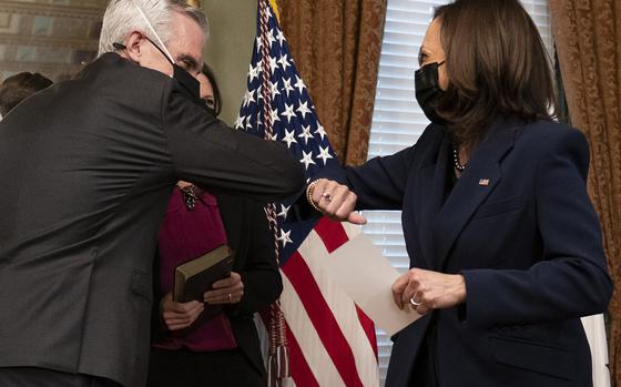 Vice President Kamala Harris, right, and Denis McDonough bump elbows after McDunough was ceremonially sworn in by Harris as Secretary of Veterans Affairs, Tuesday, Feb. 9, 2021, from her ceremonial office at the Eisenhower Executive Office Building on the White House complex in Washington. Behind them are McDonough's wife and sons. (AP Photo/Jacquelyn Martin)