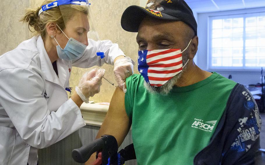 In a Feb. 4, 2021 photo, pharmacist Tara Hubbard delivers a COVID-19 vaccination to Alric Johnson, an Army veteran and resident at The Retreat, a Community Renewal Team assisted-living facility in Connecticut.
