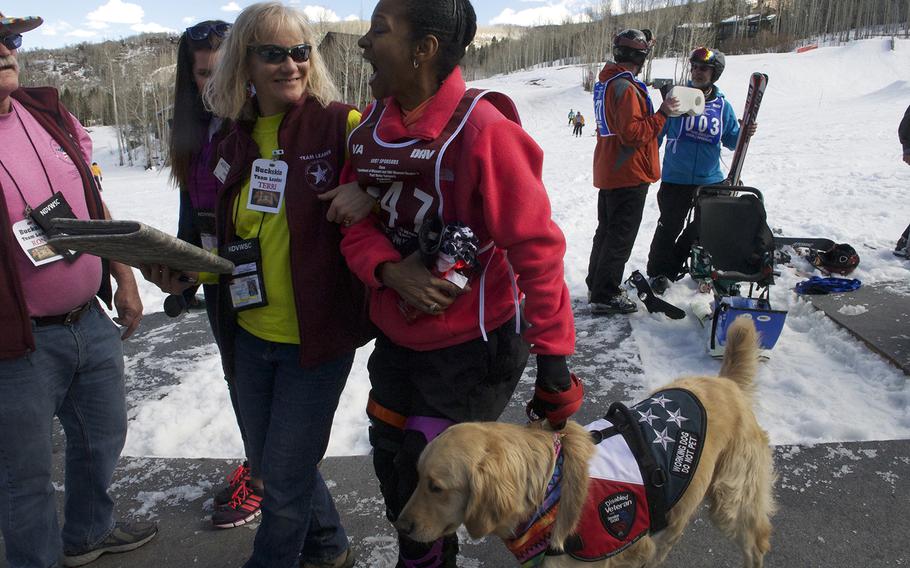 Shanda Taylor-Boyd laughs with a volunteer while leading her service dog, Timber, at the National Disabled Veterans Winter Sports Clinic at Aspen Snowmass Resort in Colorado in April 2015. The Army veteran, who suffered a brain injury in a car crash, said learning to ski at the clinic helped her become more independent in every day life.