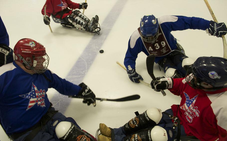 Veterans battle over the puck in a game of sled hockey at the National Disabled Veterans Winter Sports Clinic near Aspen, Colorado in April 2015.