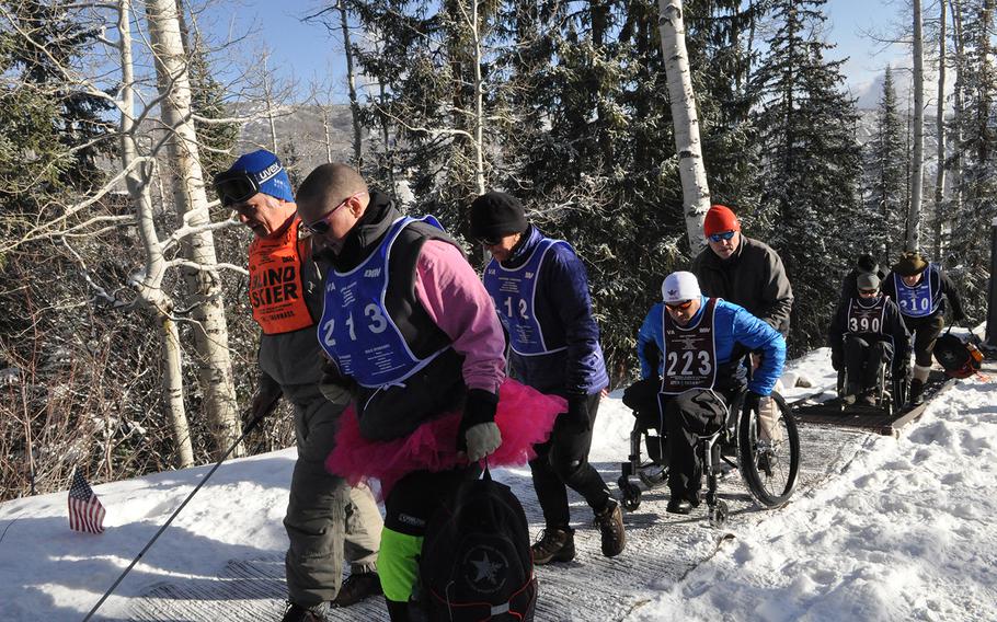 Volunteers help veterans reach the starting line of a cross-country ski race on the last day of the National Disabled Veterans Winter Sports Clinic at Aspen Snowmass Resort in Colorado in April 2015. Better care and technological advances have allowed even severely wounded veterans to participate in sports such as ski racing.