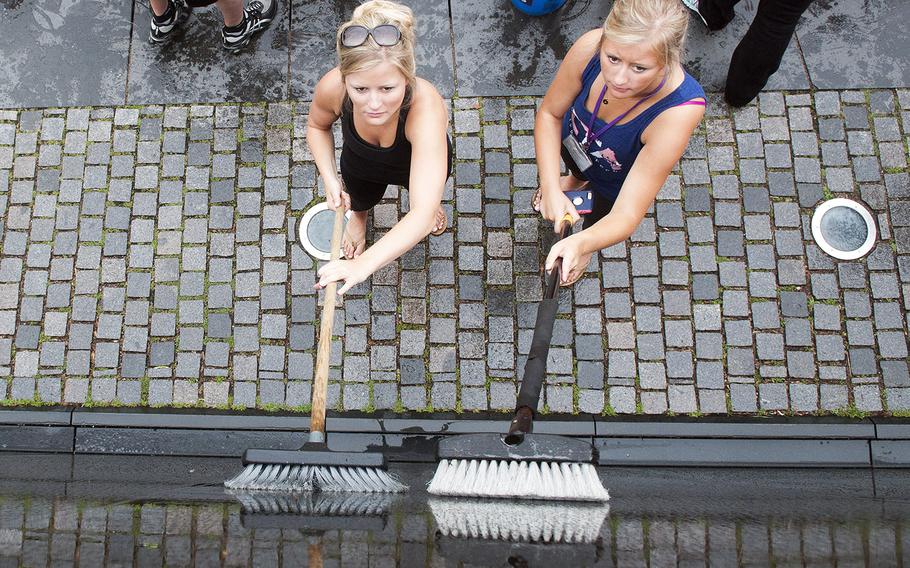 Megan Rihn, left, and her sister Alyssa, scrub granite panels Saturday, June 20, 2015, at the Vietnam Veterans Memorial Wall, where they joined dozens of volunteers for an early morning wall washing.